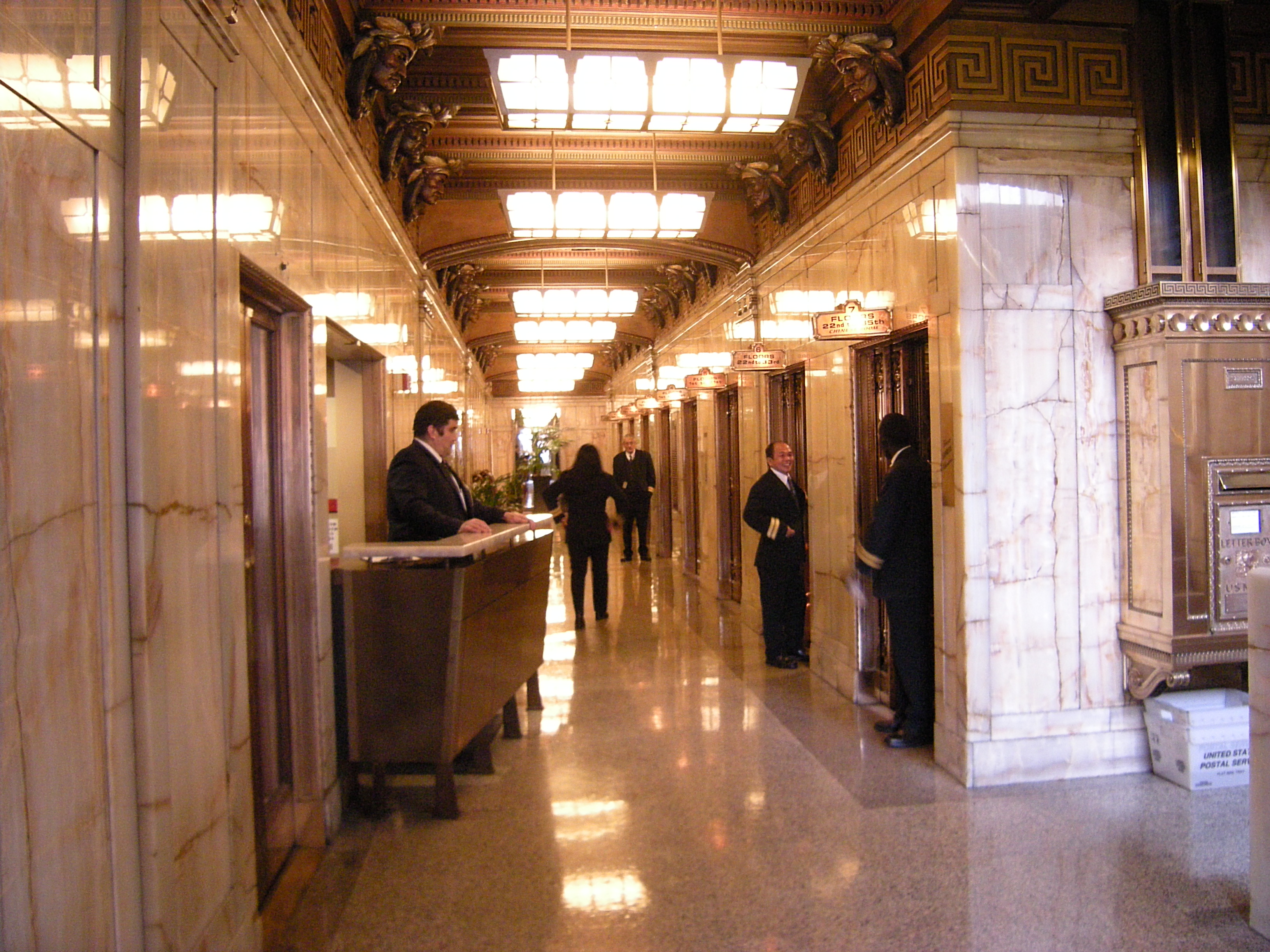 Two lift operators beside the ornate lift doors in Seattle’s Smith Tower
