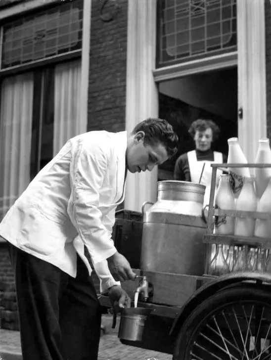 Een melkboer verkoopt zuivel aan klanten bij zijn wagen in 1956