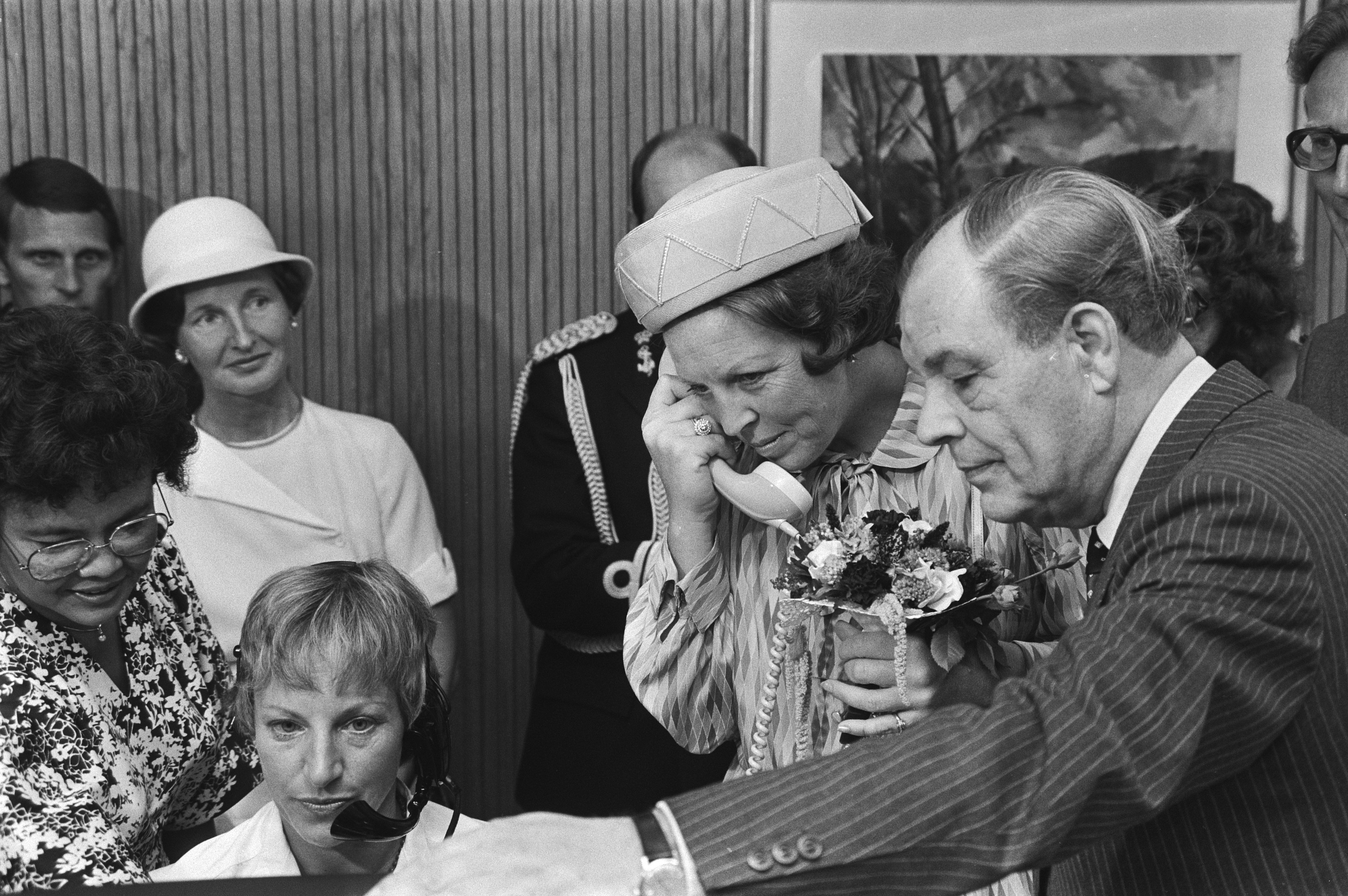 Queen Beatrix listens in with an operator on the 008 directory enquiries line during a visit to the PTT in Amsterdam, 1 September 1981.