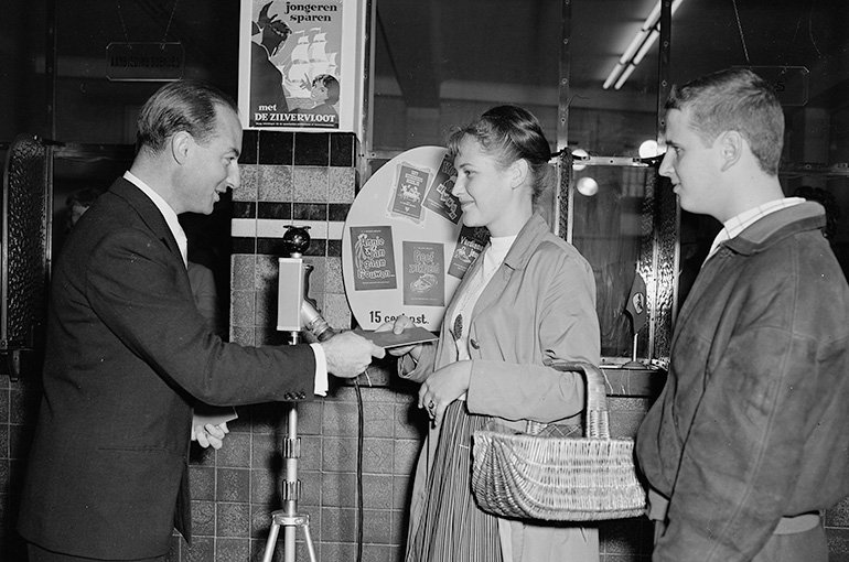 Minister Jo Cals (left) congratulates young people on opening a Zilvervloot savings account, 1958.